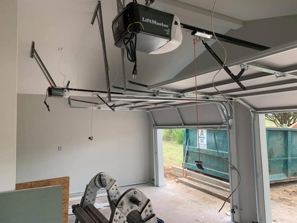 Technician installing a new commercial overhead sectional door in Metro Atlanta